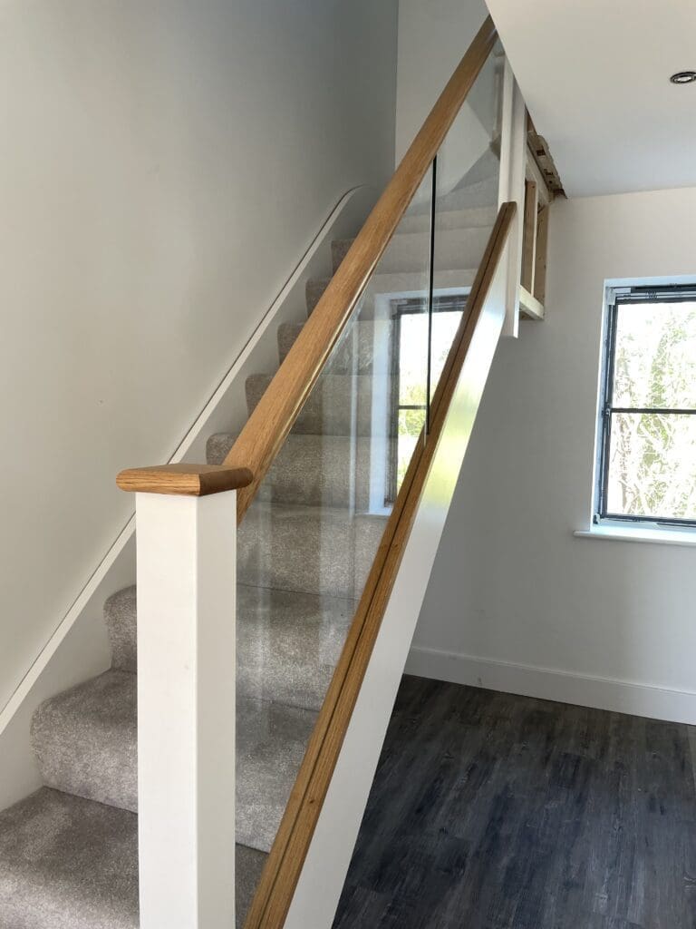 Oak timber staircase with glass balustrade infill panels