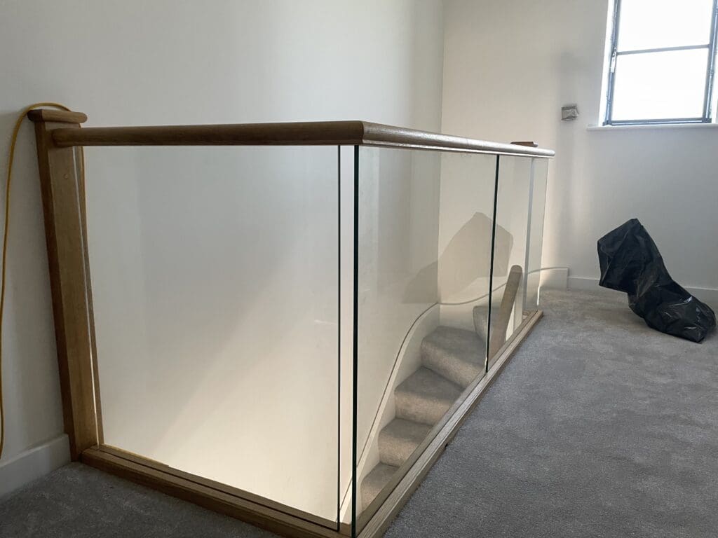 Oak timber staircase with glass balustrade infill panels
