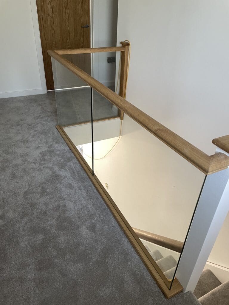 Oak timber staircase with glass balustrade infill panels