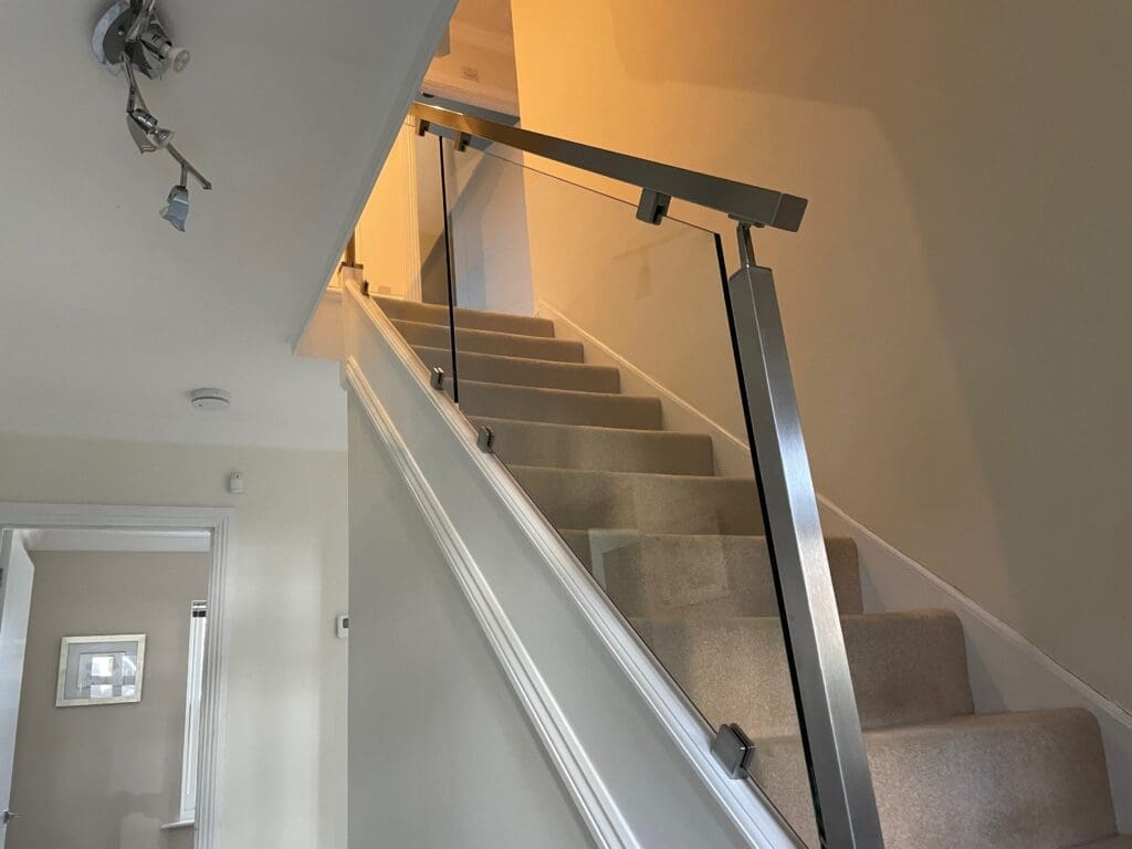 Stainless Steel handrail staircase renovation in Buckhurst Hill, Essex. Using 10mm clear toughened glass panels