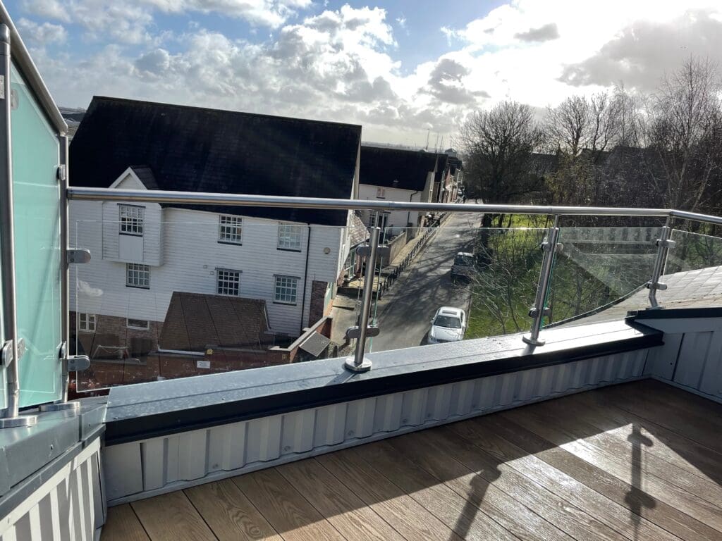 Balcony glass balustrade with a side privacy screen using a satin finish glass