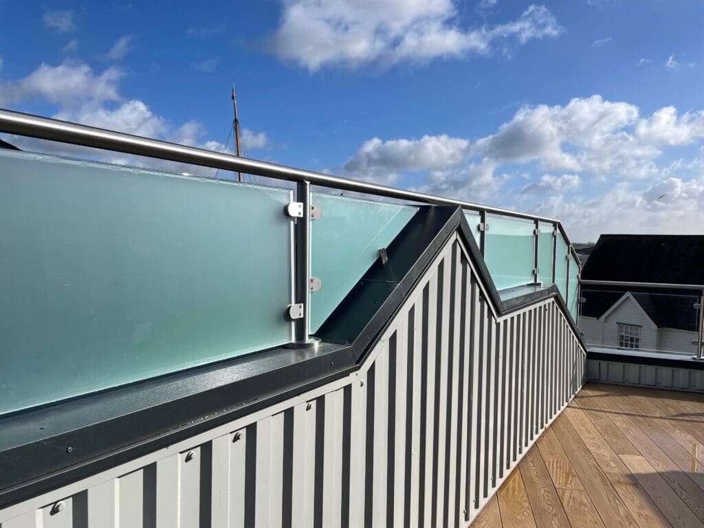 Balcony glass balustrade with a side privacy screen using a satin finish glass