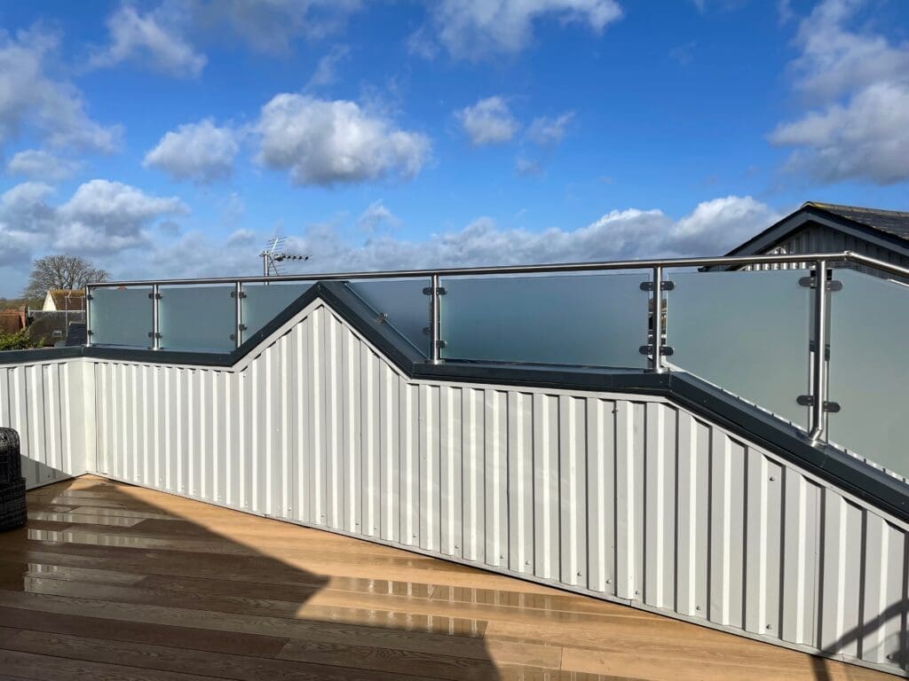 Balcony glass balustrade with a side privacy screen using a satin finish glass. Completed for a client in Essex